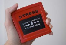 Hand holding red stress relief device.
