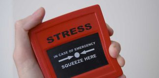 Hand holding red stress relief device.