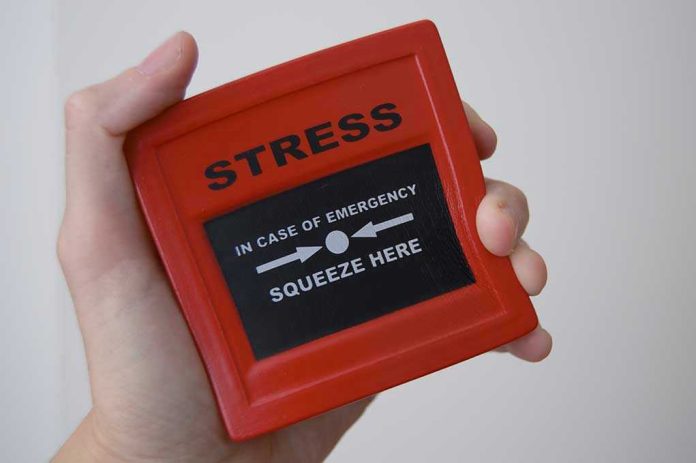 457000480 Hand holding red stress relief device.